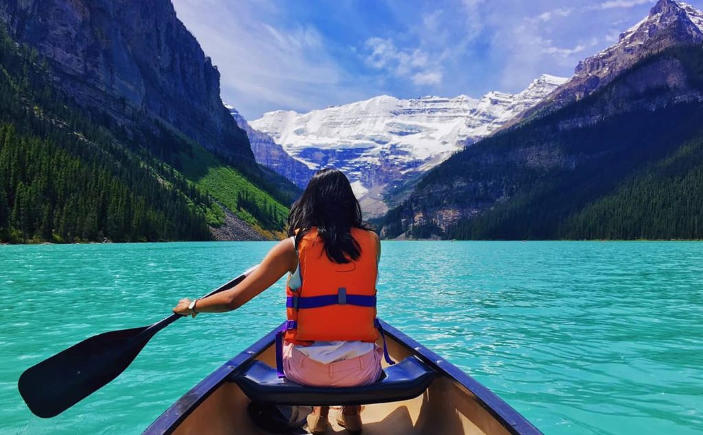 sightseeing is one of best canoe tips. This photo is of the mountains taken from a canoe on a lake.