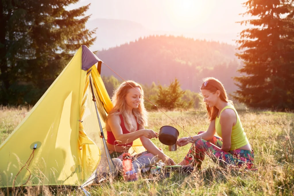 two girls camping on a hot summer day.