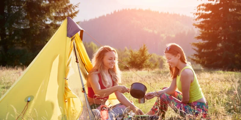 two girls camping on a hot summer day.